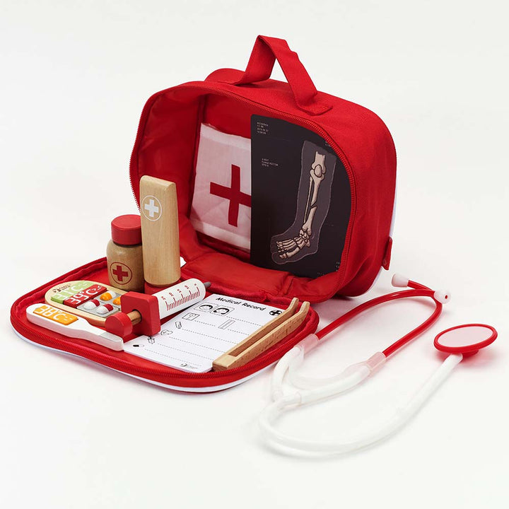 Red toy medical kit with various pretend medical tools on a white background