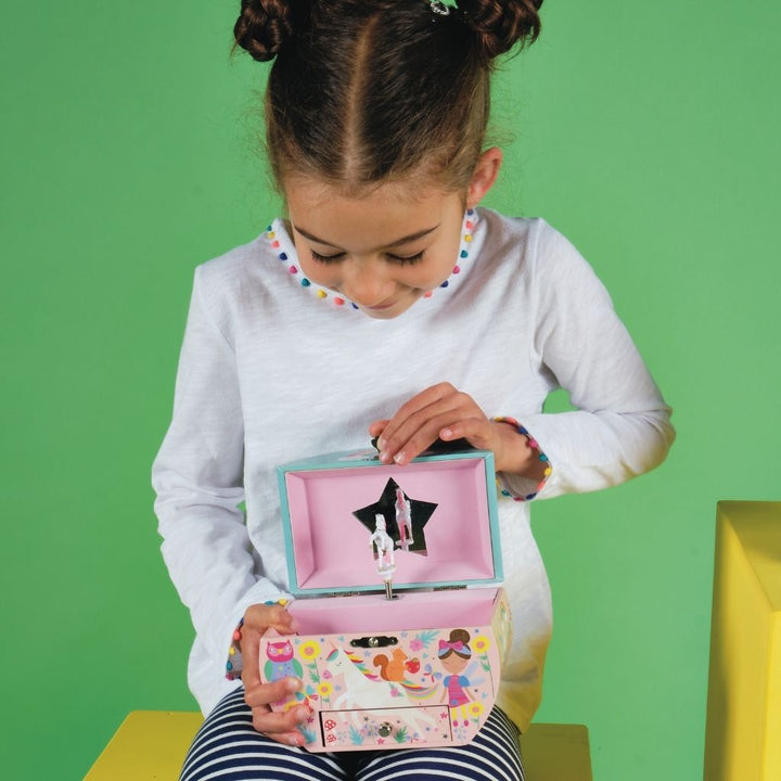 Child opening a colorful jewelry box with a green background