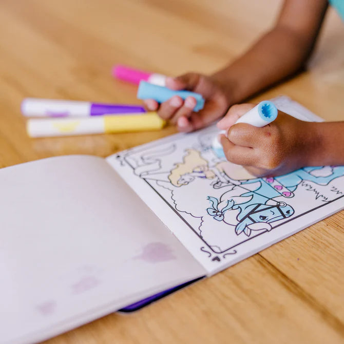 Child coloring a picture with markers on a wooden floor