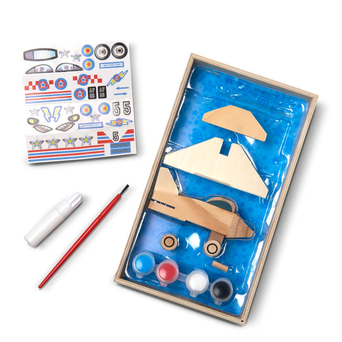 Wooden airplane kit with paint, brush, and stickers on a white background